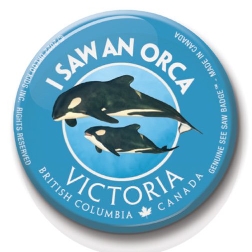 A button with two orcas on it.