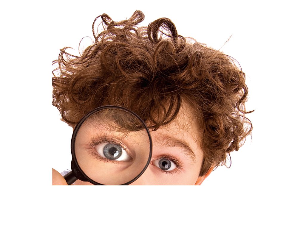 A boy with curly hair looking through a magnifying glass.
